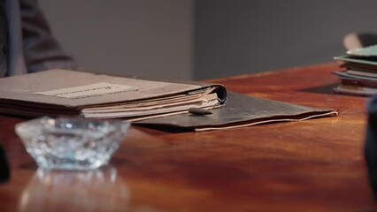 A criminal detective at his desk examines folders with documents