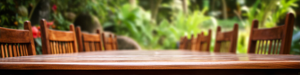 An empty wooden table with a blurred background of a lush green garden.