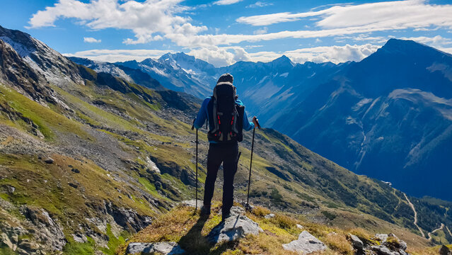 Hiker man on alpine meadow with panoramic view of majestic mount Hochalmspitze in High Tauern National Park, Carinthia, Austria. Idyllic hiking trail in Austrian Alps. Wanderlust paradise Mallnitz
