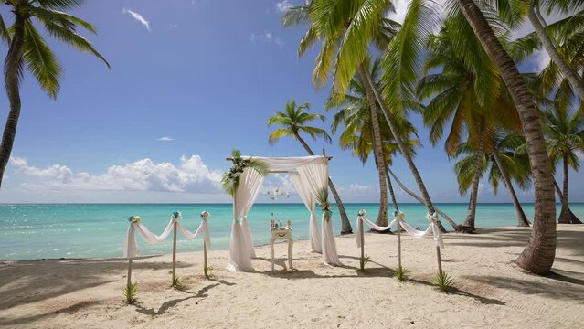 Wedding decor beach set up seaside floral roses arch sunny summer Germany. Best Wedding Western details Wood chairs gold concept. Setting stage festive marriage patterns tropical island sunset.