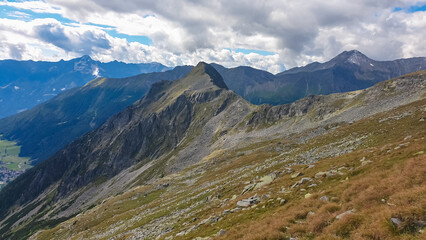 Fototapeta na wymiar Rough terrain with scenic view of alpine valley and majestic mountain peaks in High Tauern National Park, Carinthia, Austria. Idyllic hiking trail. Austrian Alps in summer. Hike paradise Mallnitz