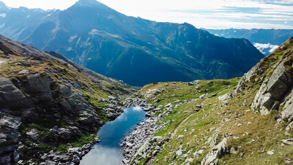 Small lake surrounded by field of rocks in High Tauern National Park, Carinthia, Austria. Idyllic hiking trail from Hannoverhaus to Hagener cottage in Austrian Alps in summer. Hike paradise Mallnitz