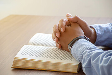 Christian man hand praying to god with the bible.