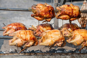Closed up Thai style grilled chicken in wooden stick ready to serve. Thai local style street food cooking.