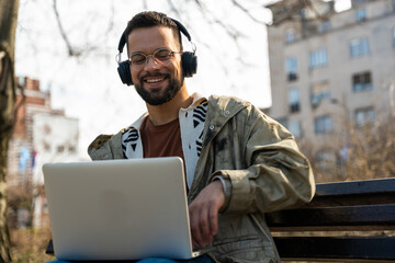 Young freelance business hipster man is work on new project outside on laptop computer....