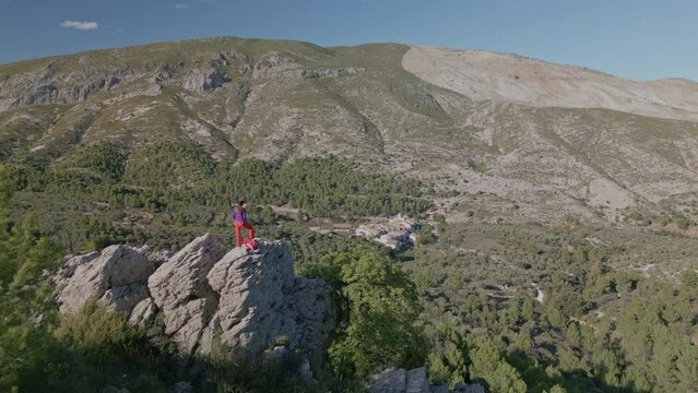 Female hiker looks out above a valley of Famorca village, Costa Blanca, Spain - stock video