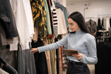 Clothing store. Fashion shop sales retail manager checks stock uses digital tablet on workplace. Small Business Owner