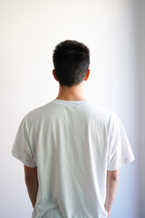 白いTシャツを着た若い男性の後ろ姿　白背景
