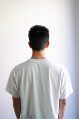 白いTシャツを着た若い男性の後ろ姿　白背景	
