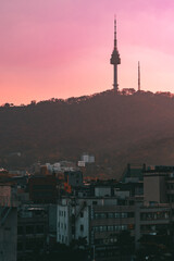 Fototapeta na wymiar Tour de Seoul au coucher de soleil avec des batiments en premier plan