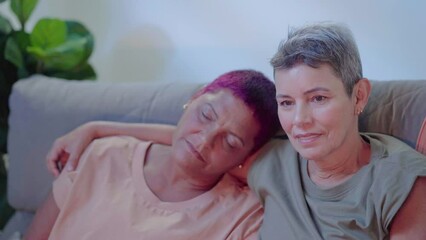 Sleepy lesbian elderly couple embracing at couch in front tv at night. Family evening concept
- Powered by Adobe