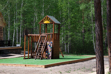 Children Playground with Modern Slide, Rope Net Bridge, Climbing Swings, Climbers. Empty Wooden Playground made of Eco Materials - Wooden Tree trunk Logs Robinia.