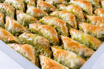 Top view of shaabiyat with pistachio baklava on tray isolated on white background. Traditional...