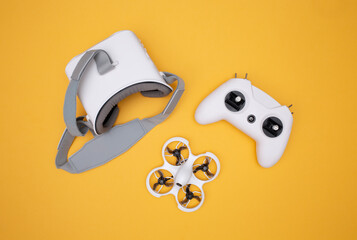 FPV drone, glasses and remote control in white on a yellow background