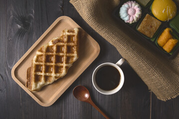 Waffles and coffee with dessert on rustic wood background