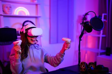 Asian young gamer girl use VR goggles headset and controller device for playing online game in entertainment neon room © MergeIdea