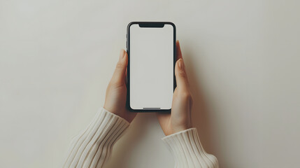 A person's hand holding a cell phone with a white screen against a white background.