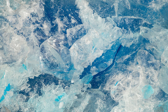 Blue ice surface with cracks background texture. close-up frozen water. broken ice.
