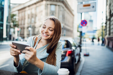 Young adult woman using a smart phone in the city