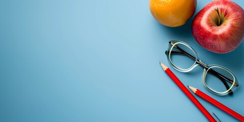 Fruit, glasses and pencils on a blue backdrop