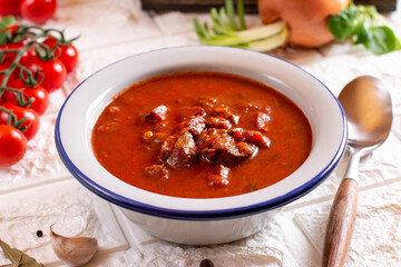 Beef goulash, soup and a stew, made of beef chuck steak and plenty of paprika on table. Hungarian traditional meal.