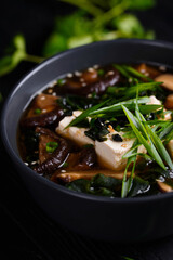 Japanese food. Miso soup. on a black wooden background.