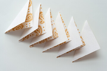 overlapping folded paper triangles on blank paper