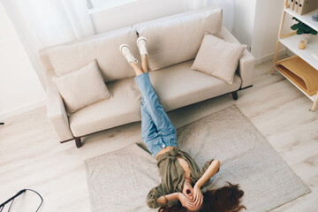 Cozy Home Sofa: Lying on a Cosy Couch, a Happy Woman Relaxing in her Modern Apartment