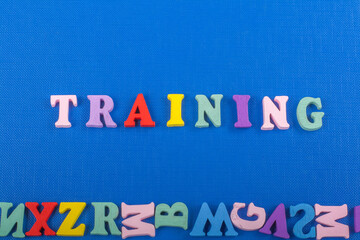 TRAINING word on blue background composed from colorful abc alphabet block wooden letters, copy space for ad text. Learning english concept.