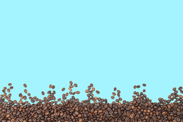 Fototapeta premium coffee beans isolated on blue background, border. Copy space for text.