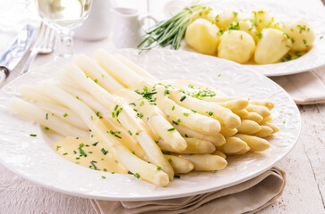 Traditional German white  asparagus with boiled potatoes served as close-up on a classic design plate