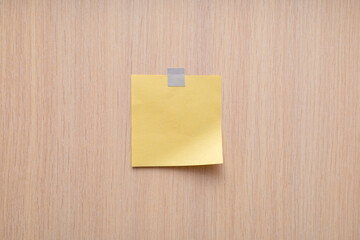 Yellow sticky note on wood