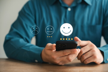 customer satisfaction survey concept business people use smartphone Touch the happy smiley icon....
