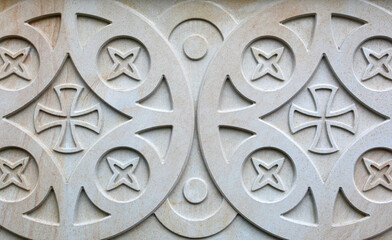 abstract pattern carved on an old stone wall, ancient texture background, vintage relief.