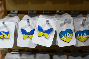 brooches in the shape of a butterfly and hearts with Ukrainian symbols. yellow-blue symbol of...