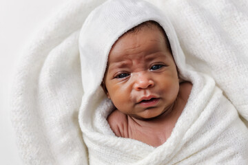 Fototapeta na wymiar Portrait of cute adorable little african american baby looking at camara in white bedroom