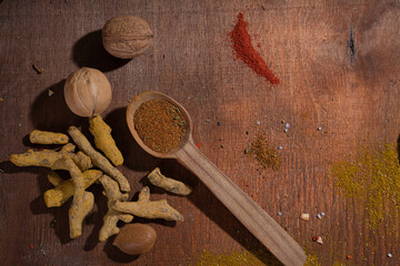 Spicy vegetable spices scattered on a wooden background