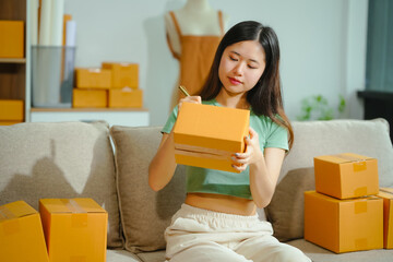 young Asian entrepreneur, the owner of a small clothing store, organizes online live streams...