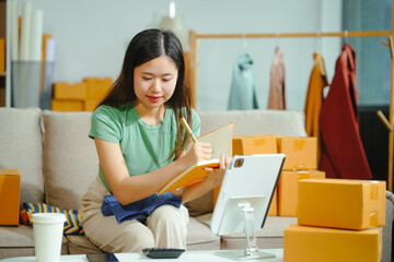 young Asian entrepreneur, the owner of a small clothing store, organizes online live streams...