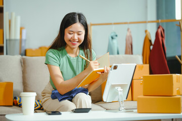young Asian entrepreneur, the owner of a small clothing store, organizes online live streams...