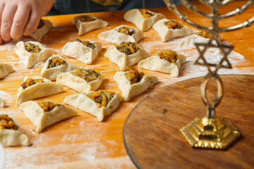 Sweet gomentashi cookies on the table in flour next to dried fruits