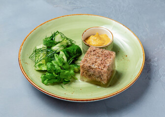 Meat jellied meat with mustard in a plate.