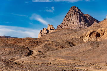 Hoggar landscape in the Sahara desert, Algeria. A view of the mountains and basalt organs that stand around the dirt road that leads to Assekrem. - 738856918