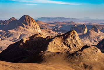 Hoggar landscape in the Sahara desert, Algeria. A view of the mountains and basalt organs that stand around the dirt road that leads to Assekrem. - 738858353
