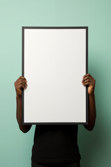 person holding up a white mockup frame in an office