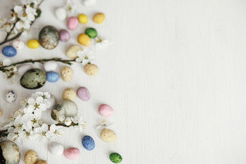 Easter flat lay. Stylish easter eggs and cherry blossom on rustic white table. Happy Easter! Easter...