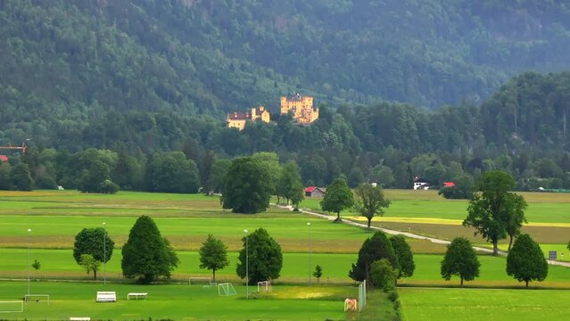 Drone wiew of the Saint Coloman church near the Neuschwanstein castle, against the backdrop of the beautiful mountains, Schwangau in the Bavarian province of Germany