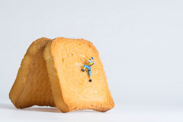 Photography of miniature people and toy figures, mountaineer climbs up a rusk