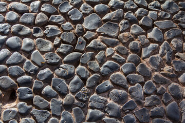 Detail of Black and gray stone textured floor with dramatic light