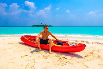 Fototapeta na wymiar Tourist man kayaking canoe boat water on Rasdhoo island Maldives.
